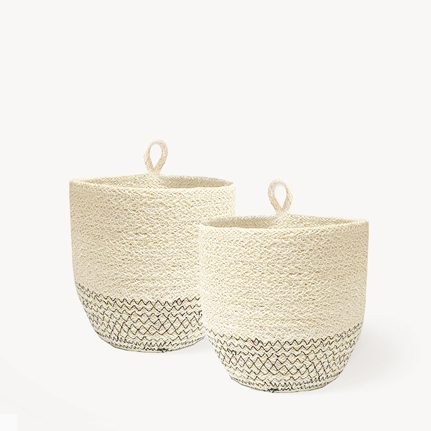 Natural jute basket beside vases of peonies and hydrangeas on white table